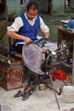 Shoerepairman resoling shoe. Jishou City, Hunan Province, China