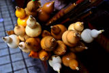Street seller with wind instruments for sale.
