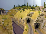 tunnel on left leads to bridge crossing the aisle (a duck-under); tunnel next to it leads to the yard; tracks above are Summit and lead to Tehachapi Loop (behind camera to the right)