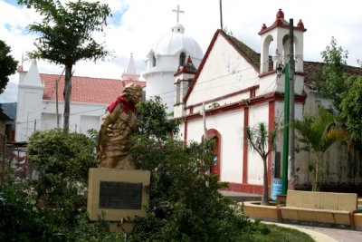 Monumento a la Madre y al Fondo la Iglesia Catolica