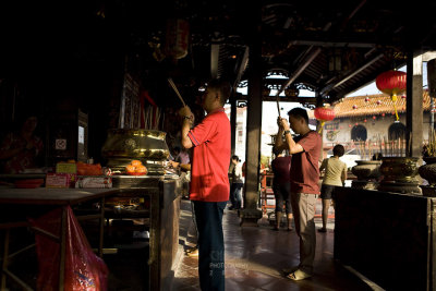 Praying with joss-sticks in hand