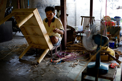 A craftsman making a rattan table.