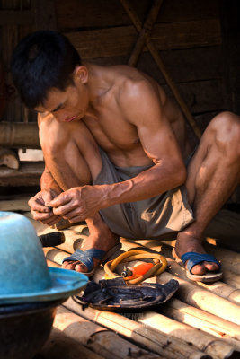 Hill tribe man doing repairs