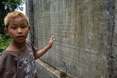 Thai boy reading stone tablet at the peak