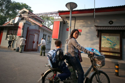 Mother taking son home from school on a bicycle