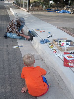 Simon watches a local artist paint our curb