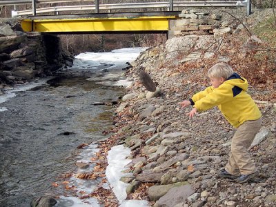 Simon tosses a (large) rock into the creek