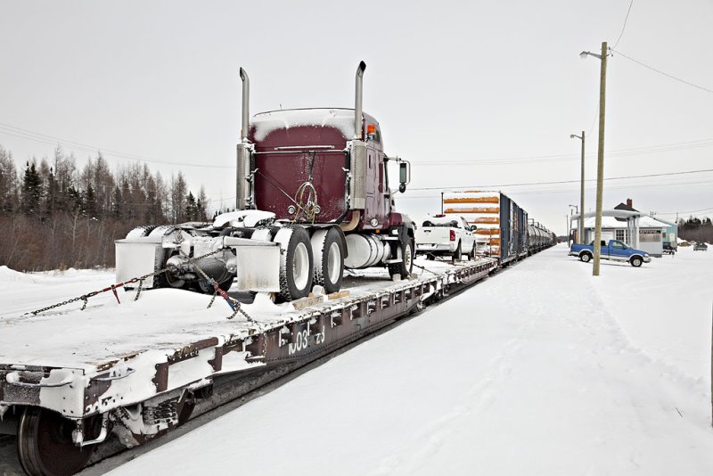 Truck on flatcar in freight train arriving in Moosonee