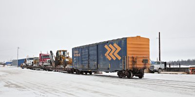 Trucks and bulldozers on siding along the river (Revillon Road North)