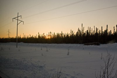 Sunset along the tracks. Winter road is between the two sets of hydro poles.