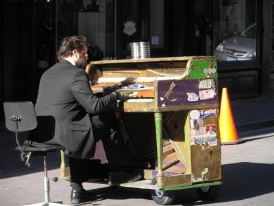 Piano on wheels, playing in the middle of the street.
