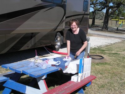 Bernice at the KOA cutting out quilt squares next to our rig,