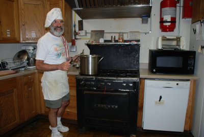 Volunteer Jeff Cohen cooking one of the last meals on the old stove.