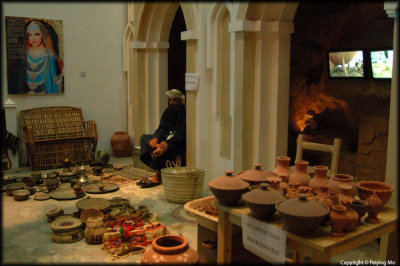 Oman: Chinese  tourists ignore the sign of No Flash Photography, the Omanese keeps stroking his foot, showing disrespect