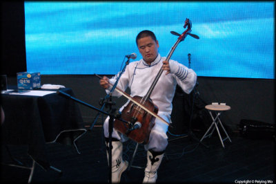 A Mongolian musician plays a traditional instrument yochin, or horse head instrument