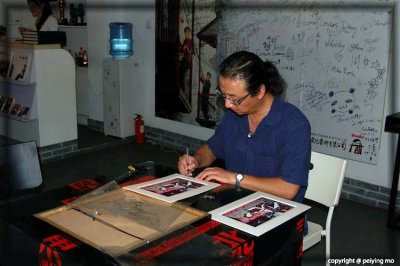 Artist Li Shoubai signing a few items we purchased.