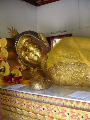 Sleeping Buddha covered with bits of gold leaf.