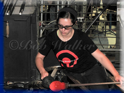 A Young Woman Works Her Glass Creation For The Audience
