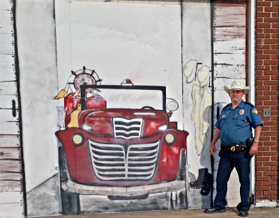 The Valley Mills Chief of Police standing beside a fire truck mural.