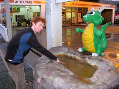 Korey warms his hands in hot onsen water along the sidewalk .