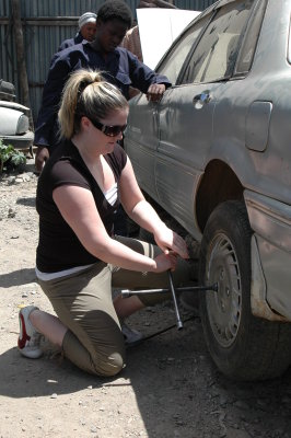 Rachelle trying her hand at changing a tire