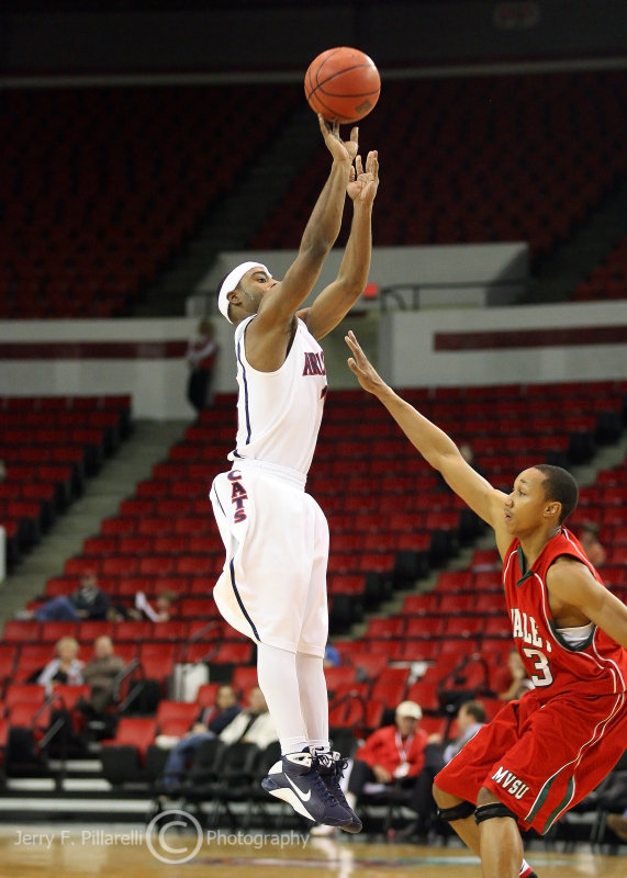 Cats G Wise takes a three pointer over Devils G Newsome