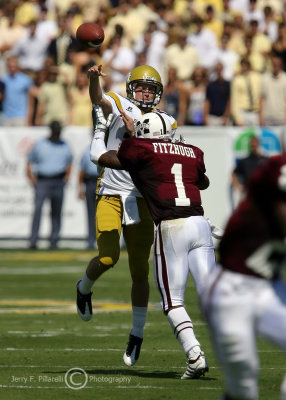 Jackets QB Jaybo Shaw gets off a pass as he is hit by Bulldogs DB Keith Fitzhugh