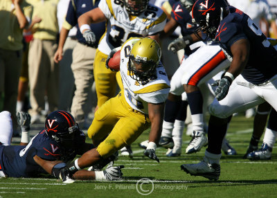 Jackets A-back Jones claws his way through Cavaliers defenders as he heads up the sidelines