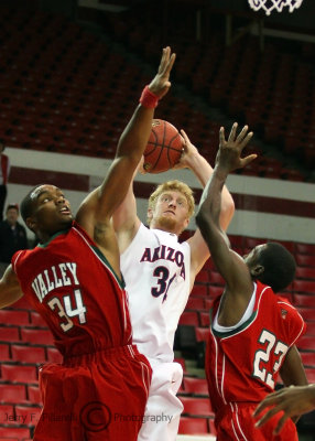 Arizona F Budinger goes up for a jumper while being defended by MVS F Petty and G Clark