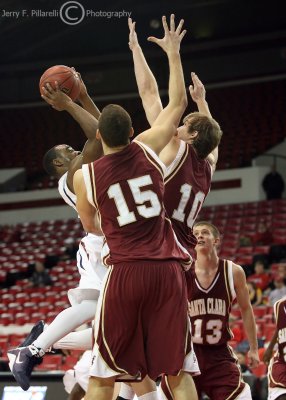 Wildcats G Wise shoots with Broncos F Trasolini and F Dowdell in his face