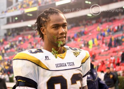 Georgia Tech DT Johnson bites down on his reward, a twig from the hallowed Georgia Hedges