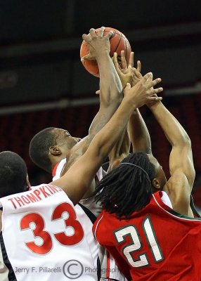 Players jostle for the ball underneath the basket