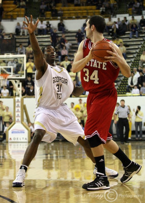 Yellow Jackets F Lawal gets his hands up while defending Wolfpack C McCauley