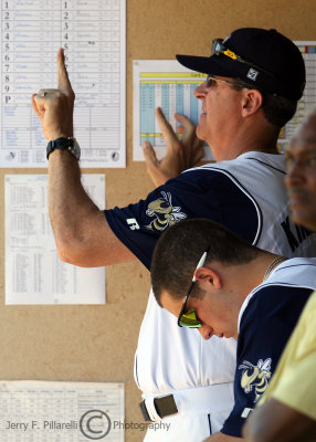 Yellow Jackets Pitching Coach Tom Kinkelaar signals a pitch into his battery