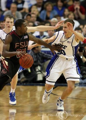 Seminoles G Douglas works his way around the perimeter while guarded by Devils G Scheyer