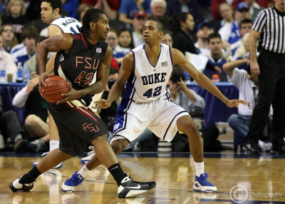 Seminoles F Reid at the three point line is guarded by Blue Devils F Lance Thomas