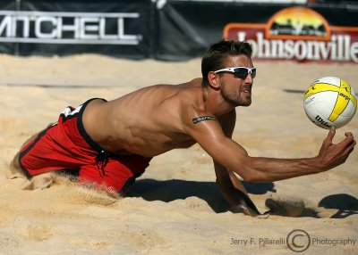 Mesko twists into the sand to bump the ball
