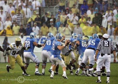 Tech DE Izaan Cross bears down on UNC QB Yates as he throws in a driving rain