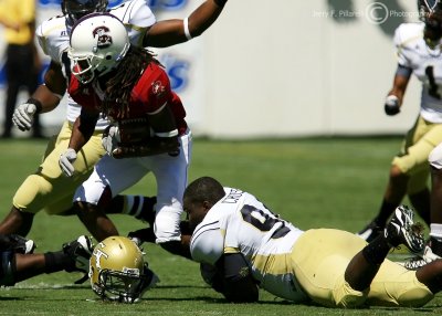 Jackets OLB Christopher Crenshaw loses his helmet but holds on to tackle Bulldogs RB Merrill