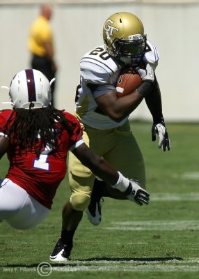 Jackets A-back Jones breaks left to avoid the tackle of Bulldogs DB Dominique Ellis