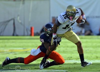 Jackets WR Earls tries to break free from the grasp of Cavaliers CB Wallace