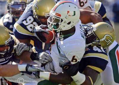 Tech OLB Egbuniwe gets an assist from teammates as he wraps up Canes RB Miller