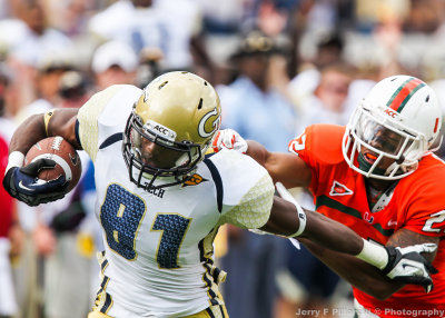 Jackets WR Jeff Greene tries to get away from Hurricanes DB Kacy Rodgers II after catching a pass over the middle