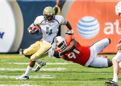 Jackets DB Jamal Golden avoids the tackle of Miami DL Olsen Pierre as he returns a kick
