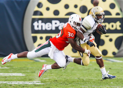 Georgia Tech A-back Zenon is brought down in the open field by Miami DB A.J. Highsmith