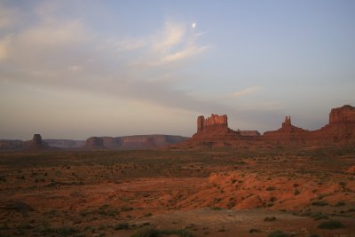 With the moon overhead, the sun rises on Monument Valley