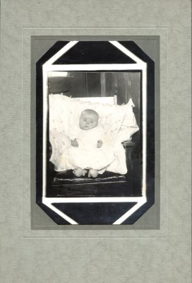 This was a personal picture placed into the frame from a professional photographer. The baby's identity escapes us at this point. If you have any idea whatsoever, who this child is, please let us know.