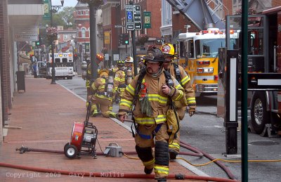 Firefighters walking towards a second building.jpg