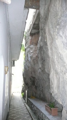 The corridor in back of the apartment house, with the rock face on the right.