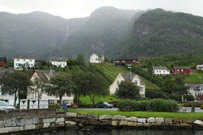 Fog and waterfall over quiet village dock 